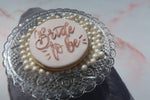 Bride to Be cookie sitting on pearls in a glass dish
